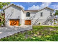 Inviting home featuring a three-car garage, manicured lawn, and charming curb appeal at 1500 Lemon Bay Dr, Venice, FL 34293