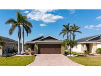 Charming single Gathering home featuring a brick paved driveway and lush tropical landscaping at 4835 San Ortebello Dr, Bradenton, FL 34208