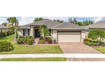 Charming single-story home featuring a two-car garage, mature landscaping, and a welcoming entryway at 5384 Layton Dr, Venice, FL 34293