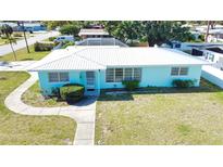 Charming single-story home with a well-maintained lawn, concrete walkway, and a light blue exterior at 100 Aurora W St, Venice, FL 34285