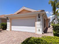 A well-maintained home with a red brick driveway and a two-car garage in a suburban neighborhood at 13166 Huerta St, Venice, FL 34293