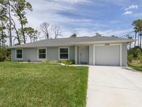 Charming single-story home boasts a well-manicured lawn and an attached one car garage at 15232 Faulkner Ave, Port Charlotte, FL 33953
