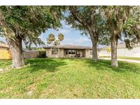 Inviting single-story home with a well-maintained lawn, mature trees, and an idyllic, peaceful setting at 1609 Kirkwood St, North Port, FL 34288