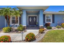 Charming home featuring a colorful front entrance and well-manicured landscaping at 194 Sportsman Rd, Rotonda West, FL 33947