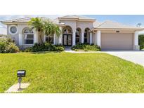 Beautiful home featuring a well-manicured lawn and double door entry framed by columns and arched windows at 201 Bayside Ct, Nokomis, FL 34275