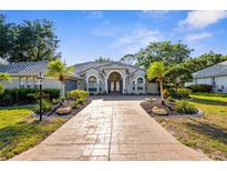 Beautiful single-Gathering home featuring a well-manicured lawn, mature trees, and a grand entrance at 2187 Calusa Lakes Blvd, Nokomis, FL 34275