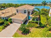 Beautiful home with a brick driveway, well-kept lawn, and a serene lake view at 2197 Mesic Hammock Way, Venice, FL 34292
