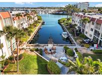 Beautiful aerial view overlooking a canal with a dock and waterfront condominium community with a courtyard and outdoor seating at 230 Santa Maria St # 333, Venice, FL 34285