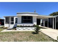 Charming single-story home featuring a carport, screened porch, and beautifully landscaped front yard at 235 Trailorama Dr, North Port, FL 34287