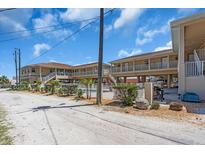 Inviting exterior of a coastal condo with a shared pool and well-maintained landscaping at 2405 N Beach Rd # 4, Englewood, FL 34223