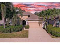 Charming single Gathering home featuring a two-car garage, mature landscaping, and a welcoming entrance at 2542 Cortenova Ct, Venice, FL 34292