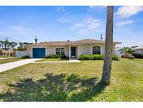Inviting home exterior with a blue garage door, front yard landscaping, and a well-manicured lawn at 511 Porpoise Rd, Venice, FL 34293