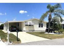 Inviting home with a car port, palm tree, manicured lawn, and a front-facing mailbox at 537 Amberjack Dr, North Port, FL 34287