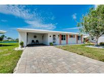 Desirable home with a brick driveway, carport, and manicured lawn, offering great curb appeal at 553 Circlewood Dr # T11, Venice, FL 34293