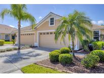 Charming home featuring a three-car garage, tile roof, and well-manicured landscaping with mature palms at 5641 Hidden Oak Ct, North Port, FL 34287