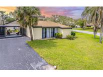 Charming home featuring a well-manicured lawn, mature palm trees, and a screened-in lanai at 633 White Pine Tree Rd # 27, Venice, FL 34285
