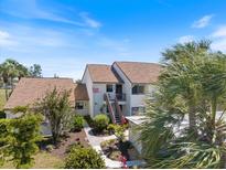 Inviting two-story condo with tropical landscaping, offering a serene and picturesque curb appeal at 726 Bird Bay W Dr # 153, Venice, FL 34285