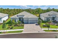 Beautiful single-story home featuring a tile roof, well-manicured landscaping, and a spacious brick driveway at 10136 Coral Shore Dr, Englewood, FL 34223