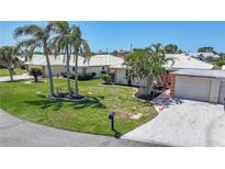 Well-manicured lawn and landscaping, mature palm trees, and tile roof create curb appeal at 120 Villa Dr # 120, Osprey, FL 34229