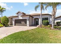 Charming single-story home featuring a well-manicured lawn, paver driveway, and two-car garage at 13872 Rinuccio St, Venice, FL 34293