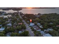 Aerial view of home showing location close to the water with mature landscaping and tree coverage at 1629 Siesta Dr, Sarasota, FL 34239
