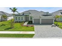 Charming single-story home featuring a tile roof, a two-car garage, and meticulously landscaped front yard at 17324 Sandpearl Rd, Venice, FL 34293