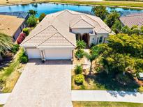 Aerial view of the house showcasing the three-car garage and surrounding landscaping at 20126 Elegante Ct, Venice, FL 34293