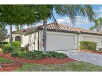Charming single-story home featuring a tile roof, two-car garage, and beautifully landscaped front yard at 20188 Tesoro Dr, Venice, FL 34293