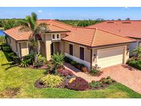 Beautiful exterior of a home with a terracotta roof, manicured lawn, and brick paver walkway at 23494 Copperleaf Dr, Venice, FL 34293