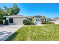 Charming single-story home with well-manicured lawn and tropical landscaping at 23516 Peachland Blvd, Port Charlotte, FL 33954