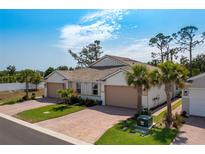 Inviting single-story home with a brick driveway and lush landscaping at 268 Ibiza Loop, Venice, FL 34292