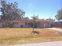 Charming single-story home with red shutters, manicured lawn and mature trees providing ample shade at 407 Bahama Rd, Venice, FL 34293