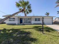 Charming home featuring a well-manicured lawn and a beautiful palm tree, creating a welcoming tropical ambiance at 444 Driftwood Rd, Venice, FL 34293