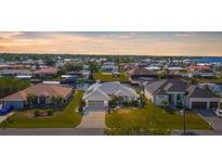 Stunning waterfront home featuring lush landscaping, a private dock, and panoramic views of the surrounding community at 5265 Neville Ter, Port Charlotte, FL 33981
