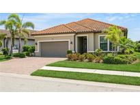 Charming single-story home featuring a terracotta tile roof and manicured landscaping at 5585 Semolino St, Nokomis, FL 34275