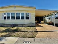 Charming home featuring a covered carport, bright siding and manicured lawn at 5619 Bayshore Rd # 421, Palmetto, FL 34221