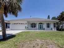 Charming single-story home with white exterior, light blue shutters, and a well-manicured lawn at 5931 Plover Rd, Venice, FL 34293