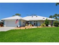Charming single-story home boasting a well-manicured lawn, clean white tiled roof, and a welcoming two-car garage at 611 Paget Dr, Venice, FL 34293