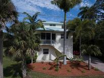 Two-story home featuring a screened-in porch, white stairs and a vibrant lawn at 770 Yale St, Englewood, FL 34223