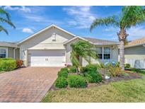 Charming single-story home with well-manicured lawn, mature palms, and a two-car garage at 8997 Excelsior Loop, Venice, FL 34293