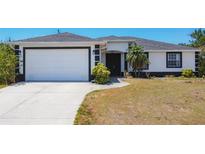 Charming single-story home featuring a well-manicured lawn, a two car garage and minimalist landscaping at 10153 Gasparilla Rd, Placida, FL 33946