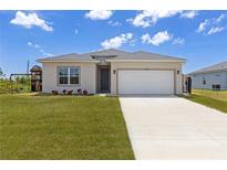 Charming single-Gathering home featuring a two-car garage and a well-maintained front lawn at 12199 Xavier Ave, Port Charlotte, FL 33981