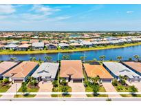 Waterfront home with barrel tile roof, and manicured landscaping at 13202 Borrego St, Venice, FL 34293