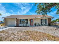 Charming single-story home featuring stone accents, a well-maintained lawn, and inviting curb appeal at 13648 Clara Ln, Port Charlotte, FL 33981