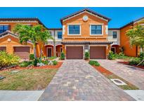 Charming two-story townhome with a brick driveway and a well-maintained front yard at 20390 Lagente Cir, Venice, FL 34293