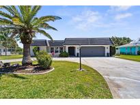 Charming single Gathering home with lush lawn, mature palm tree, and a two-car garage at 205 Cavallini Dr, Nokomis, FL 34275