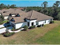 Aerial view of a home with a tile roof, manicured lawn, and a paver walkway leading to the entrance at 220 Sarezzo Cir, Nokomis, FL 34275