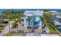 Beautiful waterfront home with a metal roof, multiple balconies, and a lush, tropical landscape at 320 O Day, Englewood, FL 34223