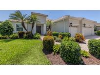 Beautiful landscaping with mature palms enhances this home's curb appeal at 353 Marsh Creek Rd, Venice, FL 34292