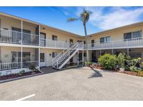 Low-rise condo complex featuring bright exterior, stairway to upper units, and a lush, well-maintained landscape at 360 Base E Ave # 413, Venice, FL 34285